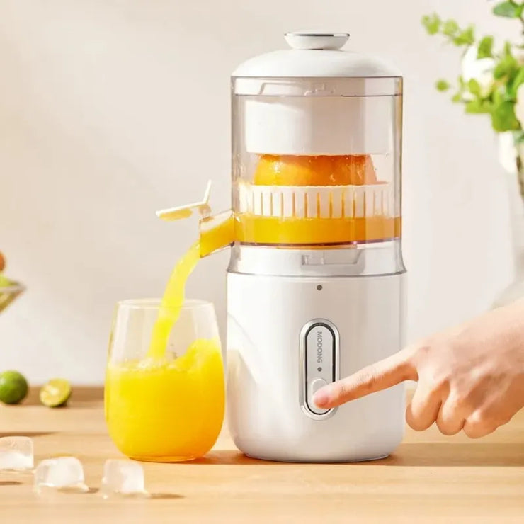 Hand juicer with a glass of orange juice on a wooden surface